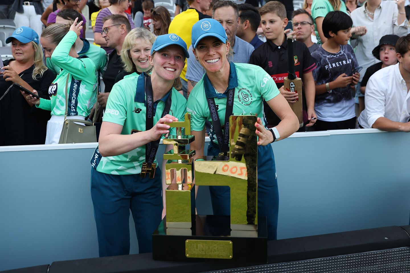 Emily Windsor and Lauren Winfield-Hill holding The Hundred trophy after winning the competition in 2022